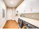 Well-lit laundry room featuring modern washer and dryer units, ample counter space, and white cabinetry at 0 Ebenezer Rd, Fayetteville, GA 30215