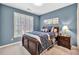 Comfortable bedroom with blue walls and a beautiful bed with blue and white decorative pillows at 5848 Deer Crossing Dr, Sugar Hill, GA 30518