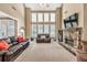 Spacious living room featuring a stone fireplace, large windows, and comfortable seating at 5848 Deer Crossing Dr, Sugar Hill, GA 30518