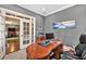 Comfortable home office featuring a large desk, built-in shelves, and bright natural light at 5848 Deer Crossing Dr, Sugar Hill, GA 30518