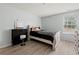 Well-lit bedroom with a bed, black dresser, and modern flooring at 112 Silver Fox Trl, Dallas, GA 30157