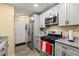 Well-lit kitchen with stainless steel appliances, grey cabinets and granite countertops at 112 Silver Fox Trl, Dallas, GA 30157