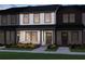 Charming two-story townhome featuring white siding, black trim, covered entryway and colorful landscaping at 2270 Ashton Dr, Conyers, GA 30013