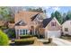 A well-manicured lawn complements this two-story house with an attached garage and a brown roof at 3270 River Summit Trl, Duluth, GA 30097