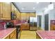 Bright kitchen with wood cabinets, red tiled countertops, stainless steel appliances, and wood floors at 3270 River Summit Trl, Duluth, GA 30097