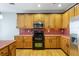 Bright kitchen with stainless steel appliances, wooden cabinets, and tiled backsplash and countertops at 3270 River Summit Trl, Duluth, GA 30097