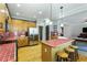 Kitchen with wood cabinets, red tiled countertops, stainless steel appliances, and an island with bar stools at 3270 River Summit Trl, Duluth, GA 30097