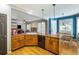 Open-concept kitchen features wooden cabinets, tile countertops, wood floors, and a view of the adjacent dining area at 3270 River Summit Trl, Duluth, GA 30097