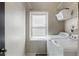 Well-lit laundry room with modern washer and dryer, shelving, and a window at 3270 River Summit Trl, Duluth, GA 30097