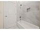Bathroom featuring a tub and shower with marbled tile and a modern shower head at 556 James P Brawley Nw Dr, Atlanta, GA 30318