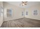 Spacious bedroom features wood-look flooring, a ceiling fan, and three bright windows at 556 James P Brawley Nw Dr, Atlanta, GA 30318