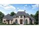 Elegant two-story home featuring stone accents, shuttered windows, and a gabled roof, set against a backdrop of trees and blue skies at 110 Godby Dr, Fayetteville, GA 30215
