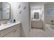 Elegant bathroom with dual vanities, decorative mirrors, recessed lighting, and a luxurious bathtub with tile surround at 211 Orchard Trl, Canton, GA 30115