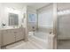 Well-lit bathroom featuring a tub and shower combination with a glass enclosure, and a vanity with storage at 211 Orchard Trl, Canton, GA 30115