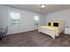 Neutral bedroom with natural light, featuring a queen bed, desk, and carpeted flooring at 211 Orchard Trl, Canton, GA 30115