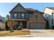 Charming brick two-story home with a well-manicured front yard and attached two-car garage at 211 Orchard Trl, Canton, GA 30115