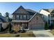 Charming two-story home features a well-manicured lawn, brick accents, attached garage, and inviting curb appeal at 211 Orchard Trl, Canton, GA 30115