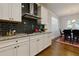 Stylish kitchen with granite countertops, stainless steel range hood, and dark backsplash at 211 Orchard Trl, Canton, GA 30115