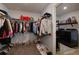 Organized walk-in closet with clothing racks and shoe storage, leading to a laundry area with modern washer and dryer at 211 Orchard Trl, Canton, GA 30115
