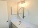Bright bathroom features a round mirror with white vanity and sink at 35 Rumson Se Ct, Smyrna, GA 30080