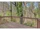 Wooden back deck surrounded by a vibrant, wooded area at 498 Pecan Wood Cir, Fairburn, GA 30213