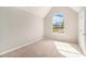 Bright bedroom with a large arched window offering neighborhood views and neutral carpeting at 498 Pecan Wood Cir, Fairburn, GA 30213