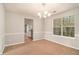Cozy dining room with chandelier lighting and a view into the kitchen, perfect for Gathering meals at 498 Pecan Wood Cir, Fairburn, GA 30213