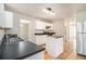 Kitchen with tile floor, stainless steel fridge, island, and dark countertop at 498 Pecan Wood Cir, Fairburn, GA 30213