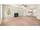 Inviting living room featuring a fireplace, ceiling fan, and seamless flow to the kitchen at 498 Pecan Wood Cir, Fairburn, GA 30213