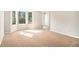 Bright living room featuring a bay window and neutral decor with beige carpeting at 498 Pecan Wood Cir, Fairburn, GA 30213