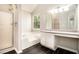 Bright main bathroom with vanity and step up bathtub beneath a large window at 498 Pecan Wood Cir, Fairburn, GA 30213
