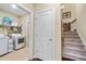Functional laundry room with storage shelving, a washer and dryer, and easy access to the stairs at 57 Cedarcrest Village Ln, Acworth, GA 30101