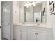 Bathroom featuring a double sink vanity with white cabinetry and a large framed mirror at 7130 Ansley Park Way, Cumming, GA 30028