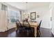 This dining room showcases a wood table, black chairs, neutral paint, and wood floors at 7130 Ansley Park Way, Cumming, GA 30028
