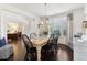 The dining room is adjacent to the office and features a wood table, black chairs, and wood floors at 7130 Ansley Park Way, Cumming, GA 30028