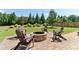 The brick firepit with Adirondack chairs is situated on a patio in the expansive yard; perfect for outdoor living at 7130 Ansley Park Way, Cumming, GA 30028