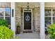 Inviting front entryway featuring a decorative door, brick facade, and well-maintained landscaping at 7130 Ansley Park Way, Cumming, GA 30028