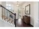 Hallway with wood floors, a wooden chest of drawers, and a view of the staircase at 7130 Ansley Park Way, Cumming, GA 30028