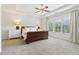 Spacious main bedroom featuring a decorative tray ceiling, ceiling fan, and large windows at 7130 Ansley Park Way, Cumming, GA 30028