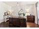 This home office features a dark wood desk, wainscoting, neutral paint, and hardwood floors at 7130 Ansley Park Way, Cumming, GA 30028