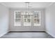 Bright dining room featuring three windows and modern chandelier with views of the backyard at 1162 Buice Lake Pkwy, Acworth, GA 30102