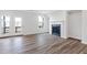 Open-concept living room with hardwood floors, fireplace, and access to a balcony at 1162 Buice Lake Pkwy, Acworth, GA 30102