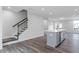 Open-concept living room with island, stainless steel dishwasher, and staircase with dark handrail at 1162 Buice Lake Pkwy, Acworth, GA 30102