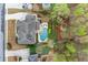 Aerial view showcasing the backyard oasis with pool, spa, fire pit, lush landscaping, and serene wooded backdrop at 3520 Millwater Xing, Dacula, GA 30019