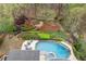 Aerial view showcases a beautiful pool, lush landscaping, and firepit, creating a private outdoor oasis at 3520 Millwater Xing, Dacula, GA 30019