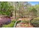 Backyard features lush greenery, mature trees, and a charming fire pit area with bench seating at 3520 Millwater Xing, Dacula, GA 30019