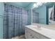 Bright bathroom with a white vanity, decorative shower curtain, and fresh blue accent wall at 3520 Millwater Xing, Dacula, GA 30019