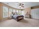 Large bedroom with a ceiling fan, multiple windows, and a wood-framed bed, creating a relaxing atmosphere at 3520 Millwater Xing, Dacula, GA 30019