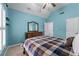 Cozy bedroom featuring a plaid comforter, light blue walls, and natural light from the shuttered windows at 3520 Millwater Xing, Dacula, GA 30019