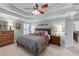 Elegant bedroom features a tray ceiling, shuttered windows, and comfortable furnishings, creating a calming retreat at 3520 Millwater Xing, Dacula, GA 30019